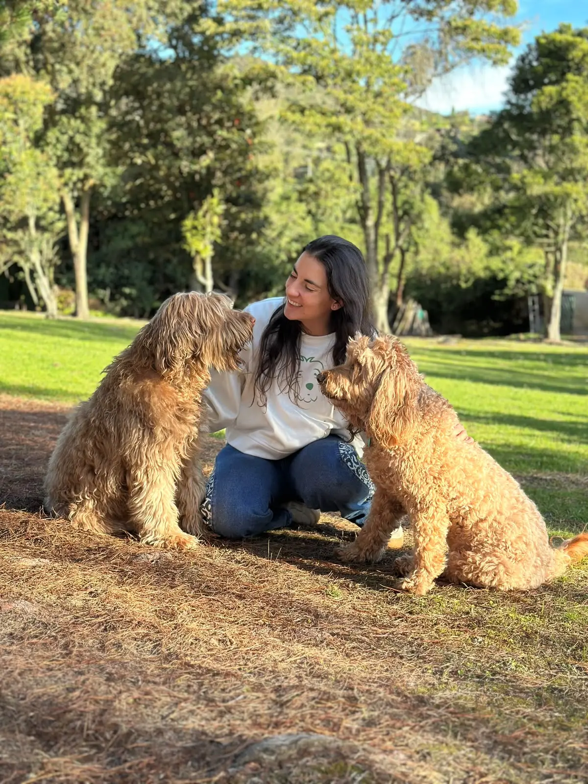 Alejandra con dos Australian Labradoodles en el parque